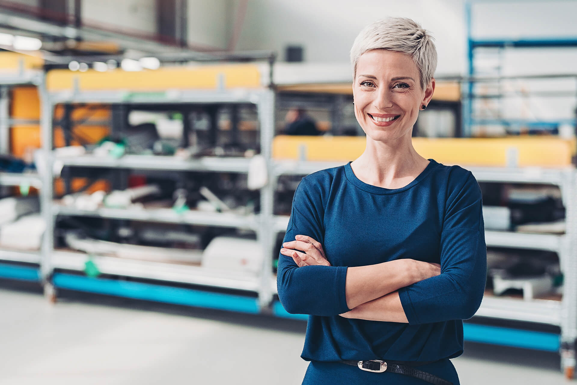 Geschäftsführerin eines Industrieunternehemens steht in Ihrer Produktionshalle